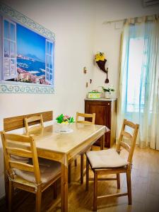 a dining room with a wooden table and chairs at Street of Naples Apartment in Naples