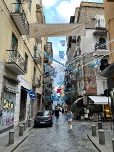 a group of people walking down a street with buildings at Street of Naples Apartment in Naples