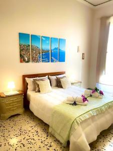 a bedroom with two beds and two tables with flowers on them at Street of Naples Apartment in Naples