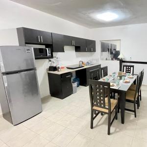 a kitchen with a table with chairs and a refrigerator at Habitacion Privada Ejecutiva Minisplit Amenidades 2 in Castillo Teresa