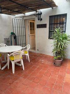 een patio met een tafel en stoelen op een bakstenen vloer bij Departamento Ocre con gran jardín in San Isidro