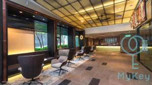 Ceylonz Suites by MyKey Global في كوالالمبور: غرفة انتظار مع صف من الكراسي والنوافذ