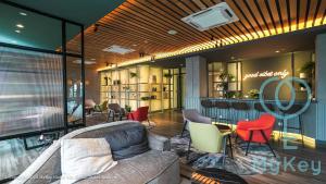 a lobby with a couch and chairs and a bar at Ceylonz Suites by MyKey in Kuala Lumpur