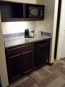 a kitchen with black cabinets and a microwave at Belfast Harbor Inn in Belfast