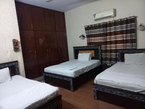 two twin beds in a room with at Al Rehman guest hous in Hyderabad