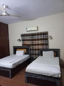 two twin beds in a room with a ceiling at Al Rehman guest hous in Hyderabad