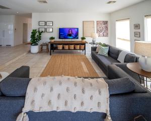 uma sala de estar com um sofá e uma televisão em Triple Creek Guest House - Barossa Region em Seppeltsfield