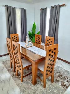 a wooden dining table and chairs in a room at Stanford Resedence in Silang