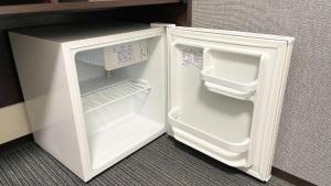 a small white refrigerator with its door open at Hotel Aston Plaza Kansai Airport in Izumi-Sano