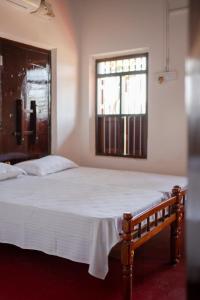 a bedroom with a large white bed with a window at Kuttanad Kayak Club by Lexstays in Alleppey