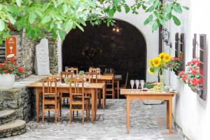 un ristorante con tavoli e sedie in legno e fiori di Majerija a Vipava (Vipacco)