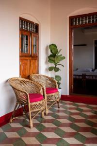 two wicker chairs in a room with a potted plant at Kuttanad Kayak Club by Lexstays in Alleppey