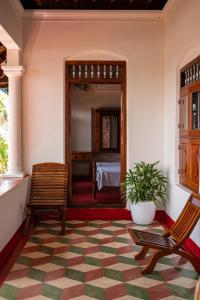a room with two chairs and a room with a bed at Kuttanad Kayak Club by Lexstays in Alleppey