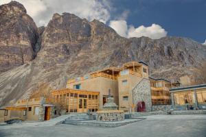 a building with a mountain in the background at Stone Hedge Hotel in Nubra