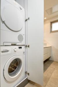 eine Waschküche mit Waschmaschine und Trockner in der Unterkunft Modern black & white by SeaU TLV in Tel Aviv