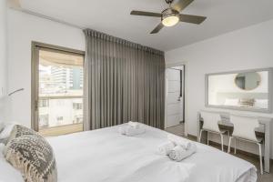 1 Schlafzimmer mit 2 weißen Betten und einem Fenster in der Unterkunft Modern black & white by SeaU TLV in Tel Aviv