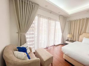 ein Schlafzimmer mit einem Bett, einem Sofa und einem Stuhl in der Unterkunft Sunshine Home 170 Từ Hoa in Hanoi