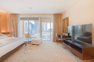 una grande camera d'albergo con letto e televisore di Classy Studio at The Address Dubai Mall a Dubai