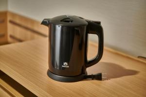 a black coffee pot sitting on a table at The Royal Park Hotel Hiroshima Riverside in Hiroshima