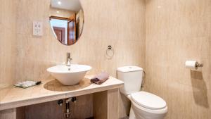 uma casa de banho com um lavatório, um WC e um espelho. em Hotel La Casa em Torrox
