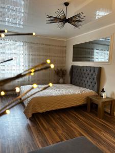 Un dormitorio con una cama grande con luces. en Апартаменти на виставці en Khmelʼnytsʼkyy
