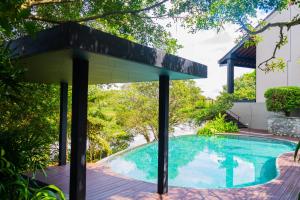 a swimming pool with a pavilion next to a house at Lily Pod in Panadura