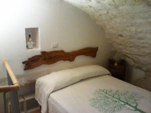 una camera con un letto con un tronco a muro di Il Nido Bianco a Ostuni