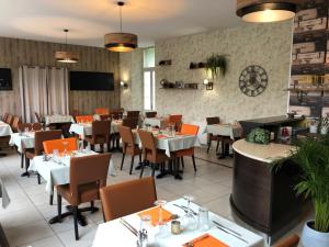 a restaurant with tables and chairs in a room at Logis Hotel Beaudon in Pierrefonds