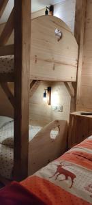a wooden bunk bed in a room with a ladder at Chez Laurette in Frémifontaine