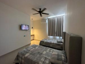 a bedroom with two beds and a ceiling fan at Departamento isla central 2 in Mazatlán