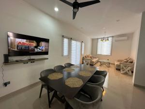 a dining room with a table and chairs and a tv at Departamento isla central 2 in Mazatlán