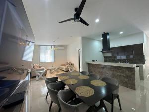 a dining room with a table and chairs and a kitchen at Departamento isla central 2 in Mazatlán