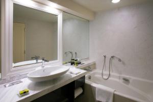 a bathroom with a sink and a tub and a mirror at InterContinental Tokyo Bay by IHG in Tokyo