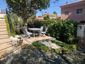 a patio with a table and chairs in a yard at Cap d Antibes, Salis beach , 2 bedrooms , free parking in Antibes