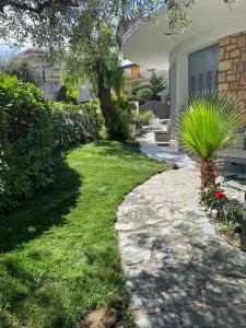 un jardin avec un arbre et une passerelle en pierre dans l'établissement Cap d Antibes, Salis beach , 2 bedrooms , free parking, à Antibes