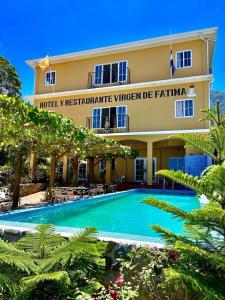 a hotel with a swimming pool in front of a building at Hotel y Restaurante Virgen de Fátima in La Ceiba
