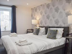 a bedroom with a large bed with towels on it at The Hideaway in Crieff