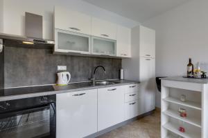 - une cuisine avec des placards blancs et un évier dans l'établissement Villa Rondine Apartments - Happy Rentals, à Novigrad