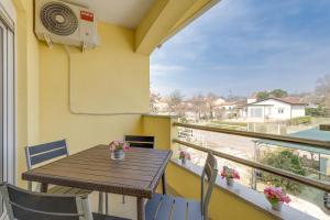 d'un balcon avec une table, des chaises et un ventilateur. dans l'établissement Villa Rondine Apartments - Happy Rentals, à Novigrad