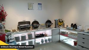 a kitchen with a counter with dishes on it at Classic Boutique Hotel Kuantan in Kuantan