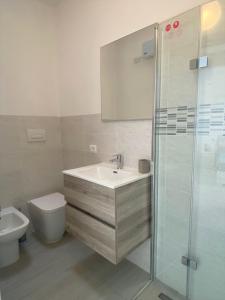 a bathroom with a sink and a toilet and a shower at Sirmione - Independent House with Garden in Sirmione