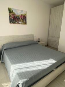a bedroom with a bed with a blue bedspread at Sirmione - Independent House with Garden in Sirmione