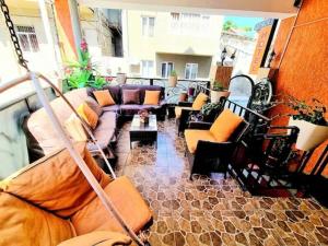 sala de estar con sofás y sillas en el balcón en Qeroli old town, en Tiflis