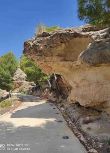 Una montaña rocosa con un camino delante de ella en Casa Cueva en Entorno Tranquilo., en Murcia