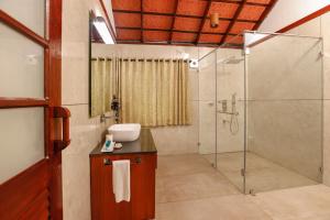 a bathroom with a shower and a sink at Vythiri Resort in Vythiri