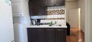 cocina con fregadero y nevera blanca en ChessKings Guest House - Unit 1, en Winnipeg