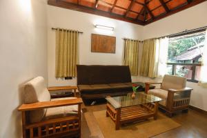 a living room with a couch and a coffee table at Vythiri Resort in Vythiri