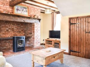 sala de estar con chimenea y estufa de leña en Brookside Cottage - Uk42869 en Burntwood