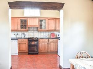 Burntwood的住宿－Brookside Cottage - Uk42869，厨房配有木制橱柜和瓷砖地板。