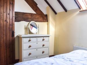 a bedroom with a white dresser and a mirror at Brookside Cottage - Uk42869 in Burntwood
